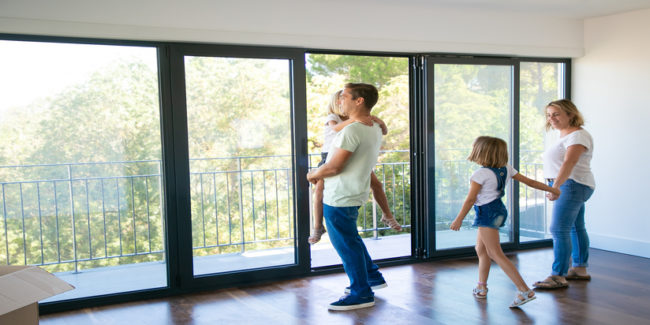 Happy father with daughter standing near open balcony